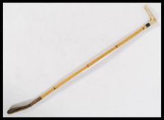 A vintage early 20th century riding crop having a tapering bamboo shaft with shaped bone handle,
