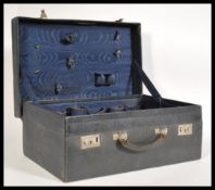 A vintage early 20th century navy blue leather 1920's suitcase having a fitted watered silk fabric