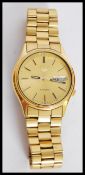 A contemporary seiko 5 automatic stainless steel watch with an Arabic date window, stick markings on