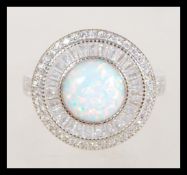 A 20th century Art Deco style ring with a large round central opal and cz set into the head and