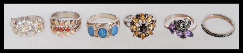 A collection of silver vintage rings to include a 925 silver ring with inlaid blue opals, a floral