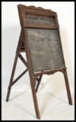 A vintage early 20th century arts & crafts oak blackboard having easel back with paper alphabet