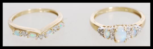 A pair of 9ct gold Birmingham hallmarked ladies rings with inset opals. The first having a large