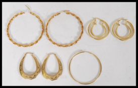A collection of contemporary costume jewellery yellow metal hooped earrings to include a pair of