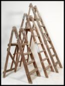A group of three vintage 20th Century Industrial wooden step ladders, the three step ladders in