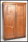 A 19th century Victorian school oak bookcase cupboard having twin doors opening to reveal