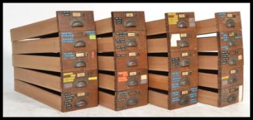 A collection of twenty - one early 20th Century industrial cabinet drawers, cup and cover brass