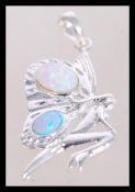 A silver pendant in the form of a fairy having two inset opals weighing 3.3g.