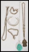A collection of 20th century silver jewellery to include a silver engraved bangle, a hand of hamsa