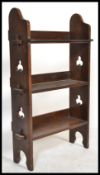 A Victorian Arts & Crafts oak open bookcase shelf having pierced sides with a series of central