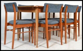 A vintage retro 1960's teak extending dining table and chairs with concealed leaf, of rectangular
