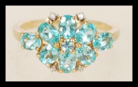 A 9ct gold ladies ring with blue stones in a prong settings including 4 inlaid diamonds, the item