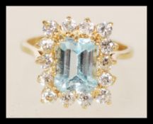 A hallmarked 9ct gold ring with an inset square blue stone surrounded by smaller white stones in