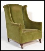 A 19th century Victorian mahogany wing back armchair with turned legs and ceramic castors