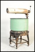 A vintage retro industrial Magic Washing Machine having a large enamel tub with press atop. Makers