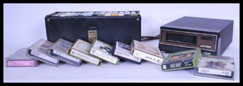 A vintage retro 20th century 8 track player along with a collection of 8 track cassettes.