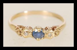 A 20th century hallmarked  9ct gold ladies ring with a central blue stone flanked by two diamonds in
