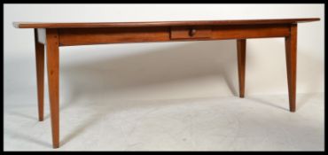 A large 20th century fruit wood refectory dining table being raised on splayed tapering  legs with