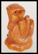 A wooden netsuke figurine in the form of a cobra snake with bamboo.