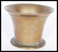 A brass 18th century trumpet shaped mortar with a circular foot base and engraved rim.