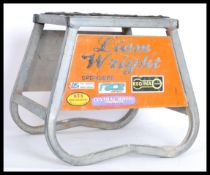 A 20th Century metal tubular frame Motorcycle work stand, the tubular frame with applied advertising