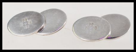 A pair of 20th century boxed silver cuff links marked 2000 onto an oval front face and chain