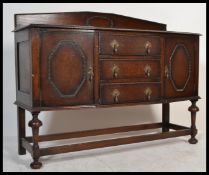 A 1930's oak sideboard dresser being raised on cup and cover supports with cupboards and central