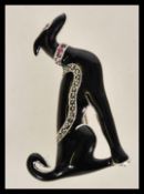 A 20th century silver and enamel brooch in the form of a dog with inset red stones and marcasites