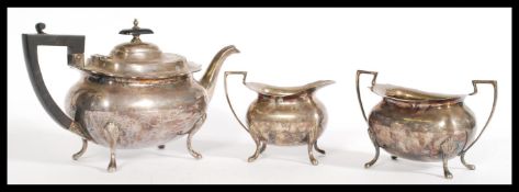 A vintage early 20th century Walker and Hall silver tea set with pad feet and shell form shoulders