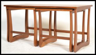 A vintage retro 20th century teak wood nest of tables having a long coffee table with two smaller