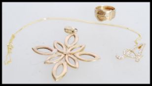 A 9ct gold ring with belt detailing and floral engraving with a letter A pendant with white stone