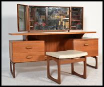 A vintage retro 20th century G-Plan teak mirror back dressing table and matching stool. Raised on