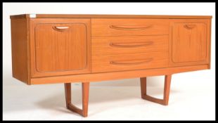 A vintage mid century teak veneer sideboard with 3 drawers to middle and doors on either side.