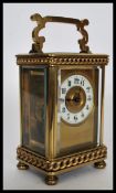 A 20th century gilt brass carriage clock raised on bun feet with curb link chain decoration. The