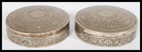 A pair of Persian Iranian silver white metal trinket boxes of circular form with Islamic geometric