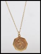 A hallmarked 9ct gold St Christopher's necklace pendant set to a yellow metal necklace chain.
