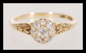 A late 19th century marked 18ct gold ring set with mine cut diamonds around a central stone of