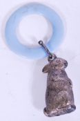 A silver white metal early 20th century babies rattle in the form of a rabbit having blue plastic
