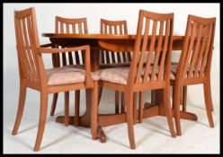 A vintage retro 20th century G-Plan teak dining table having a circular top with extending folding