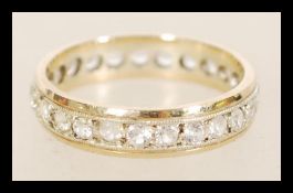 A 20th century yellow and white metal eternity ring with channel inlaid white stones, item weight is