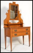 An Edwardian satin walnut dressing table chest, fitted with two long drawers raised on square