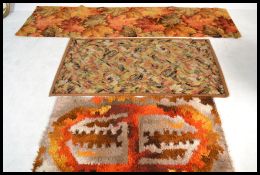 A group of three vintage 20th century retro floor carpet rugs one having maple leaf design along