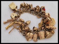 A hallmarked 9ct gold charm bracelet having a heart padlock clasp along with a good quantity of