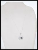 A 20th century silver pendant necklace featuring the Chanel logo with inset cubic zirconia and