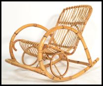 A bentwood bamboo Thonet style rocking chair with a shaped seat and foot rest and curved arms.