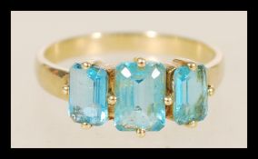 A hallmarked 9ct gold ring with three blue square stones in prong settings the item weighs 2.3 grams