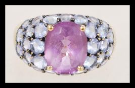 A contemporary stamped 9ct gold ladies ring with a purple amethyst with prong settings surrounded by