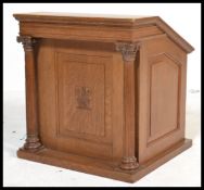 An early 20th century oak Masonic reading lectern having sloped top with carved and reeded