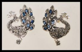 A pair of vintage stud earrings in the form of peacocks with inset marcasites and sapphires.