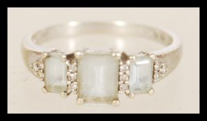 A hallmarked white gold ring with three inset white stones in prong settings item weight 2.8